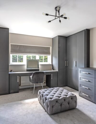 Image of bedroom with fitted wardrobes, dressing table and drawers