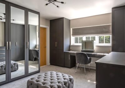 Image of bedroom with fitted wardrobes, dressing table and drawers