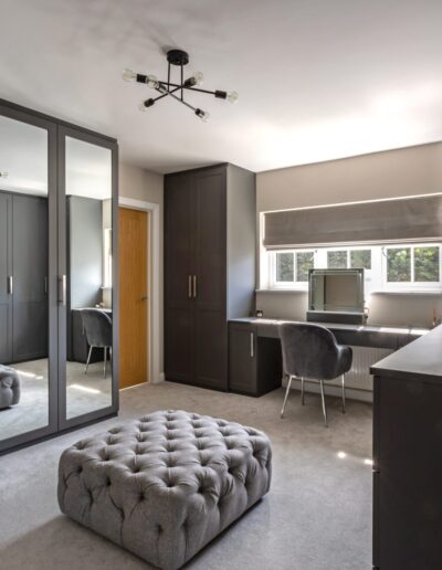 Image of bedroom with fitted wardrobes, dressing table and drawers