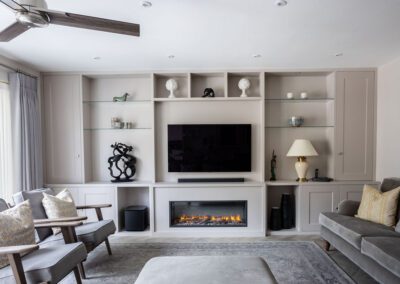 Image of a living room with a grey media unit and fire surround