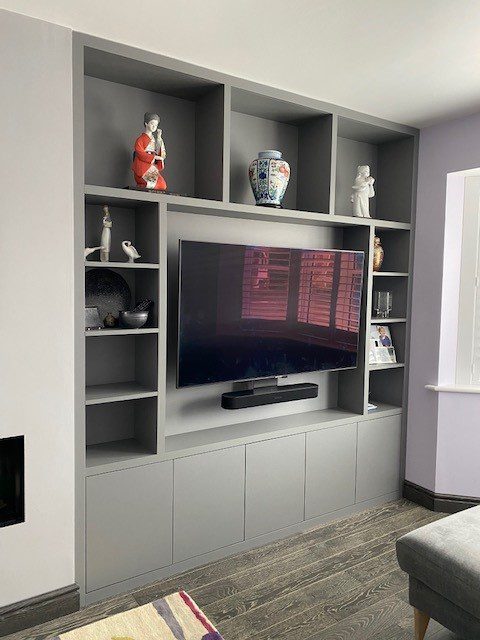 Image of a living room with a grey media unit and shelving